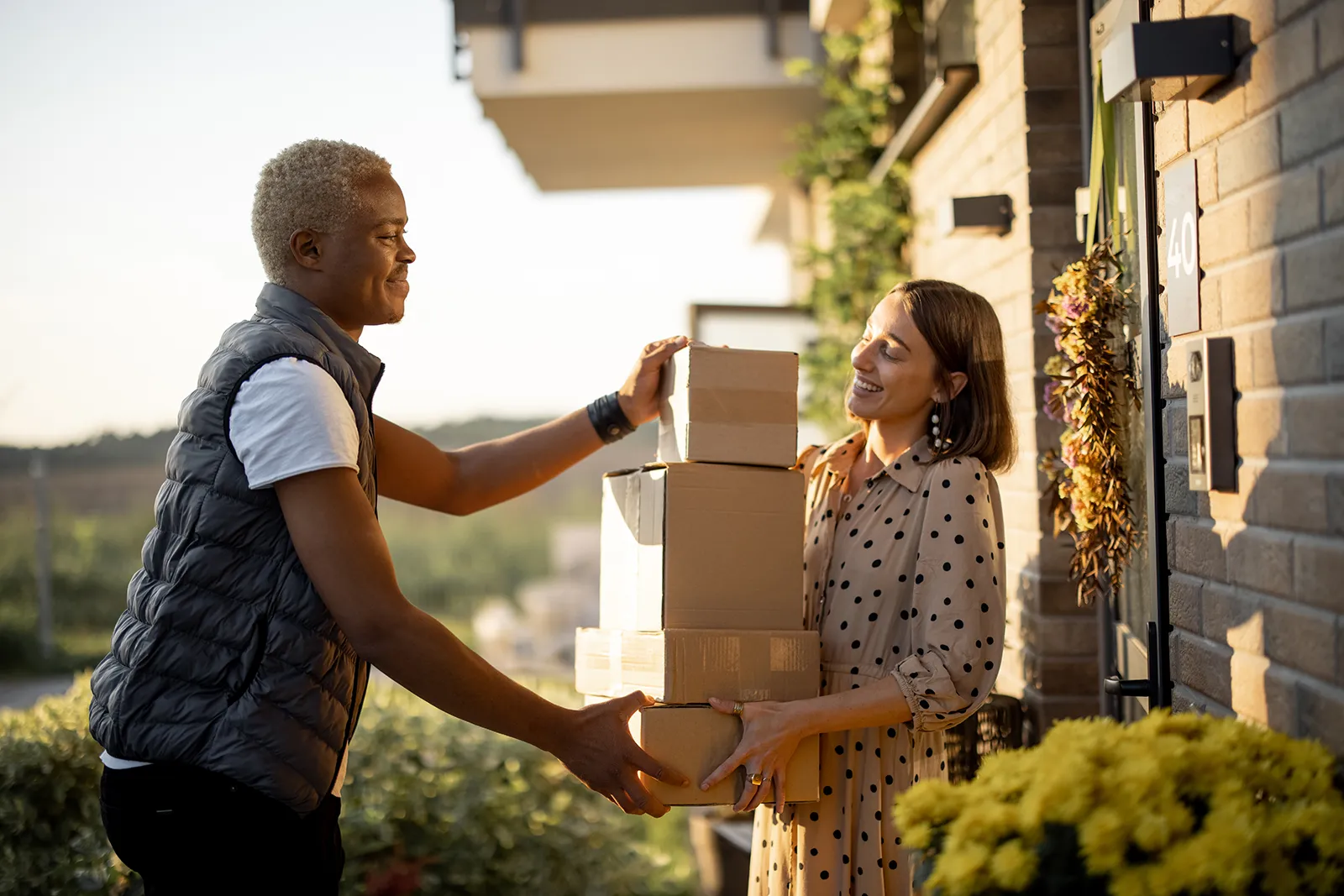 delivery-man-giving-parcels-to-caucasian-woman-2023-11-27-05-33-26-utc